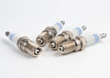 A set of four new spark plugs ready for installation and indexing