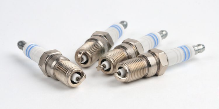 A set of four new spark plugs ready for installation and indexing