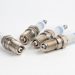 A set of four new spark plugs ready for installation and indexing