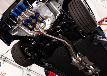 Underside of a performance car with an aftermarket exhaust being installed